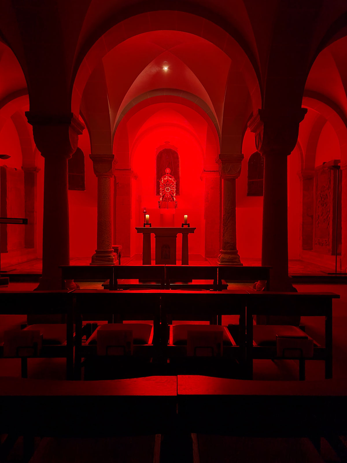 Anbetung in der rot illuminierten Krypta des Bonner Münsters
