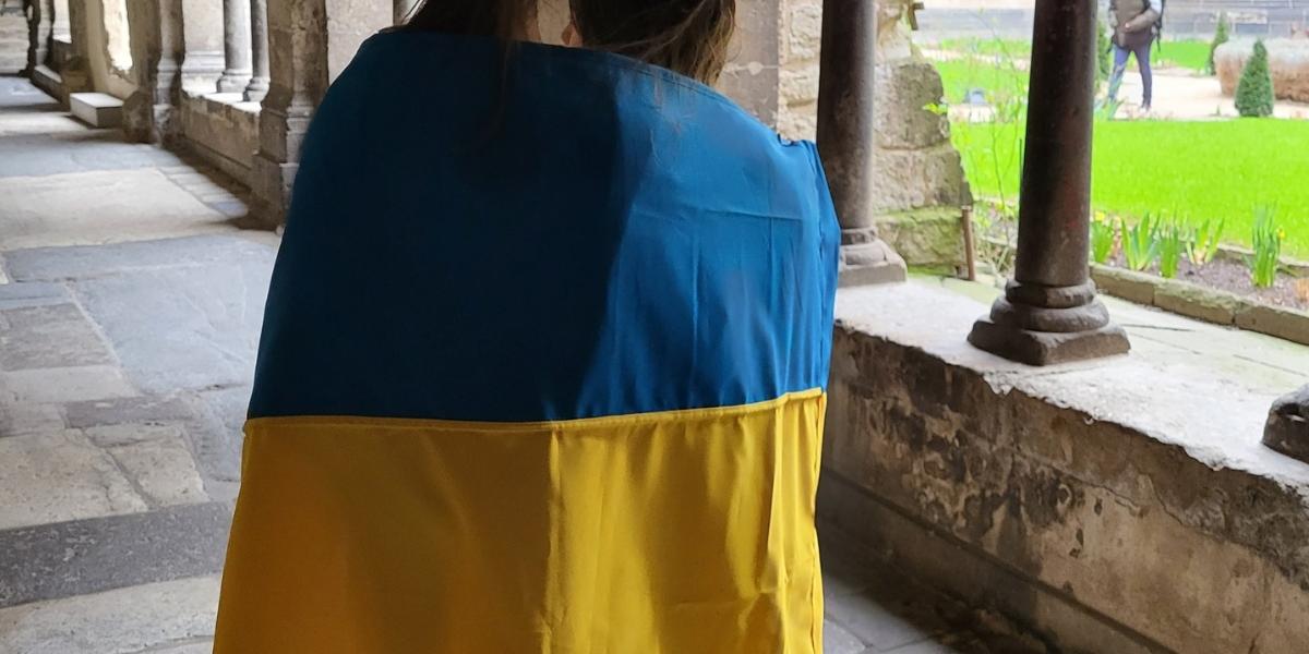 Hoffnung auf Frieden: Schülerinnen mit der Ukraine-Flagge im Kreuzgang des Bonner Münsters