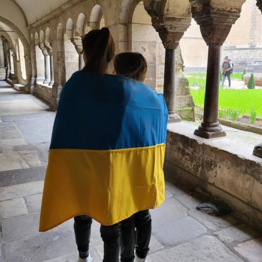 Hoffnung auf Frieden: Schülerinnen mit der Ukraine-Flagge im Kreuzgang des Bonner Münsters