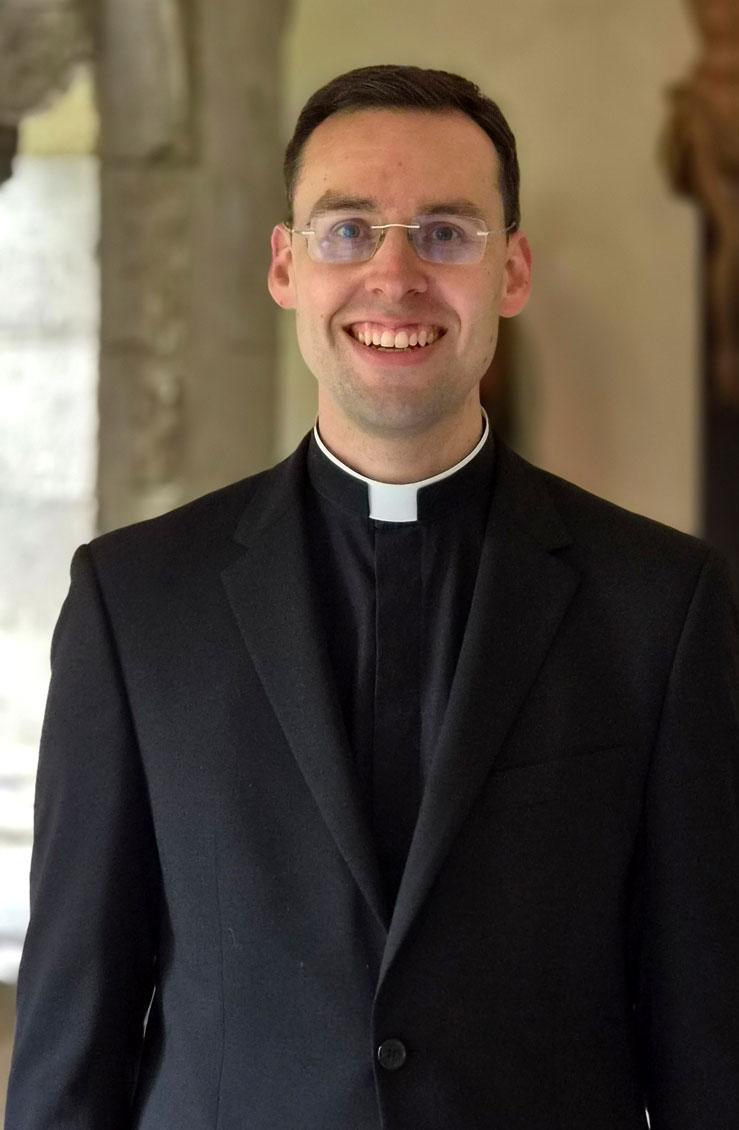Kaplan Dr. Dominik Grässlin im Kreuzgang des Bonner Münsters
