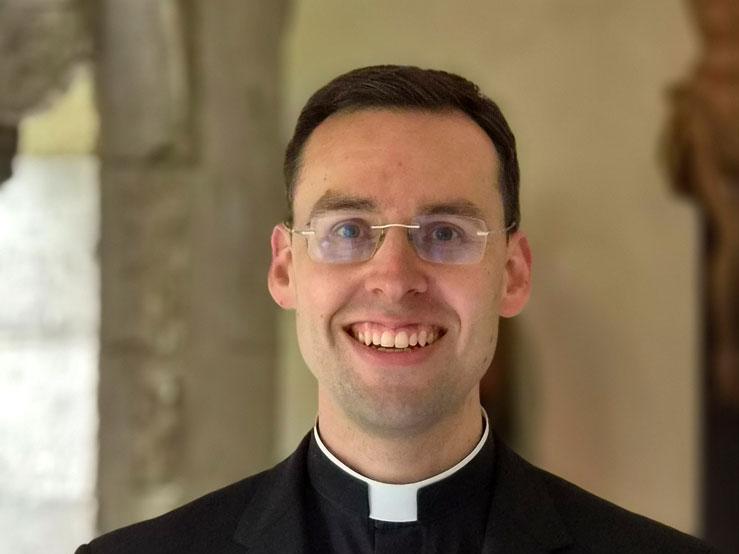 Kaplan Dr. Dominik Grässlin im Kreuzgang des Bonner Münsters
