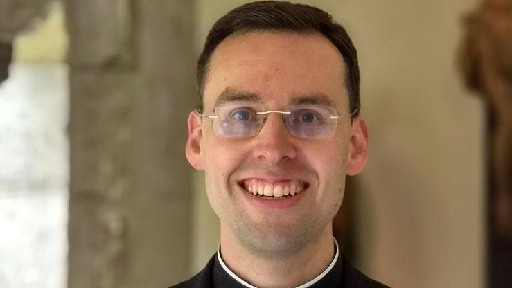 Kaplan Dr. Dominik Grässlin im Kreuzgang des Bonner Münsters