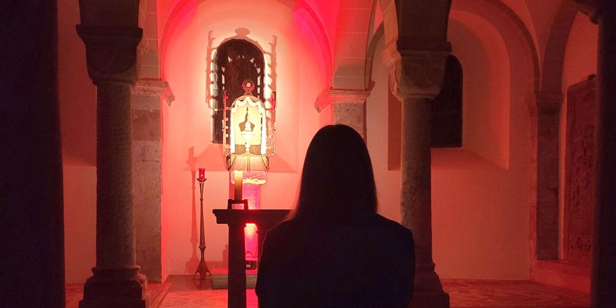 Junge Frau kniet betend