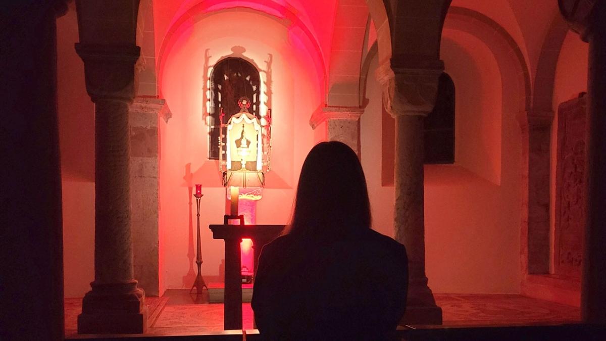 Junge Frau kniet betend