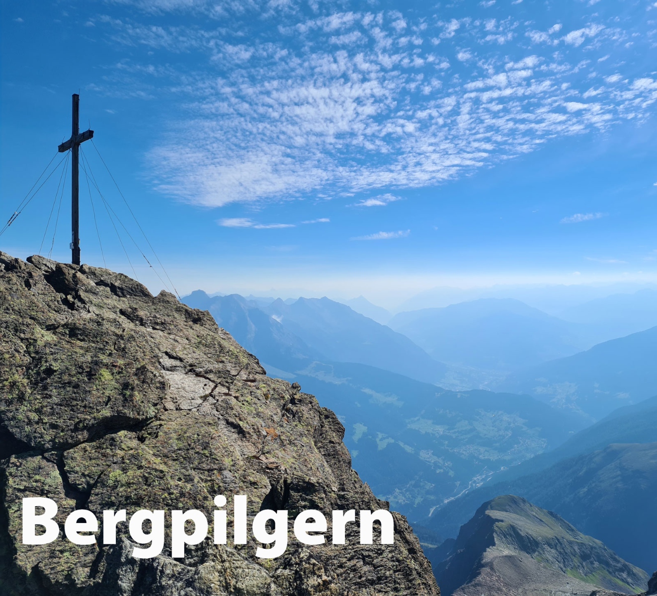 Gipfelkreuz vor Bergpanorama