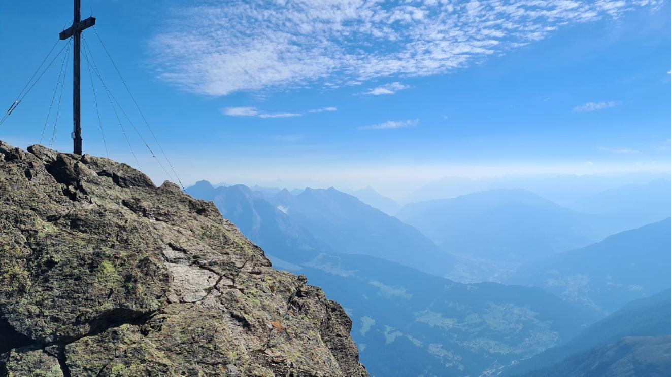 Gipfelkreuz vor Bergpanorama
