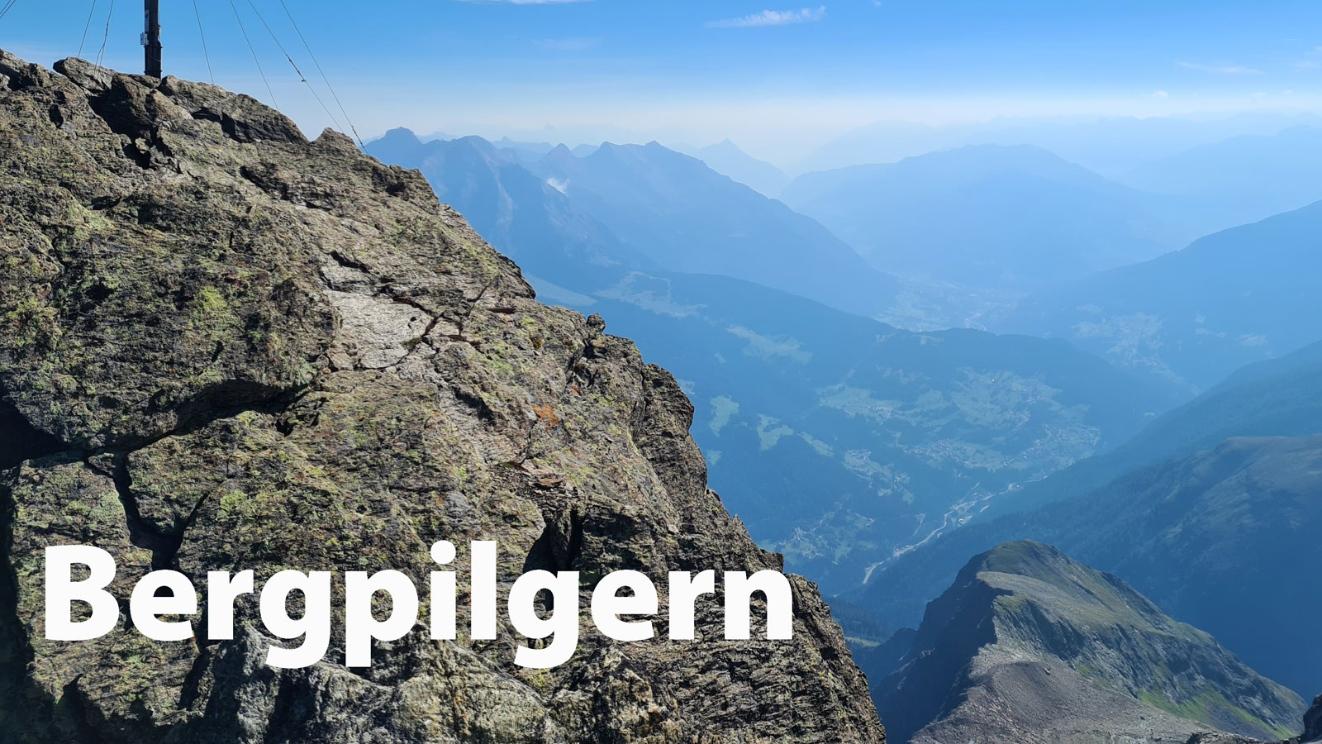 Gipfelkreuz vor Bergpanorama