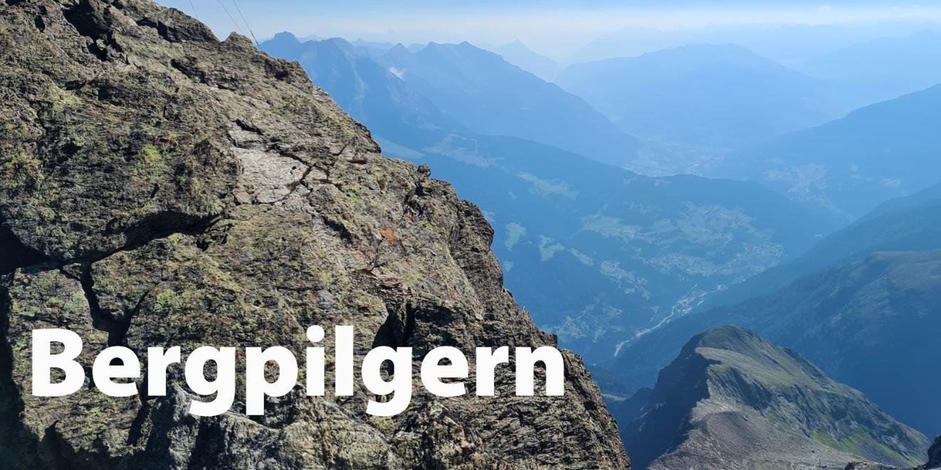 Gipfelkreuz vor Bergpanorama