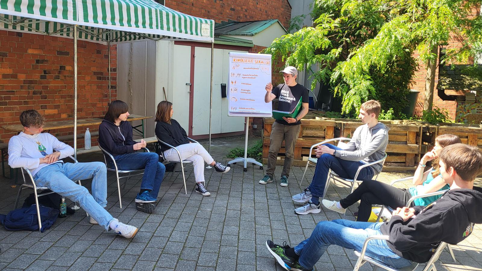 Junge Menschen sitzen im Stuhlkreis